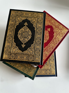 Decorative Qur'an volumes with gold-embossed covers in several colours